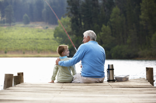 senior man fishing with grandson