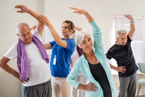 Senior adults doing stretching exercises with healthcare instructor